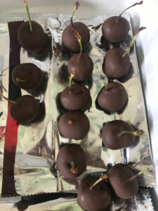 Cherries dipped in chocolate drying on a sheet